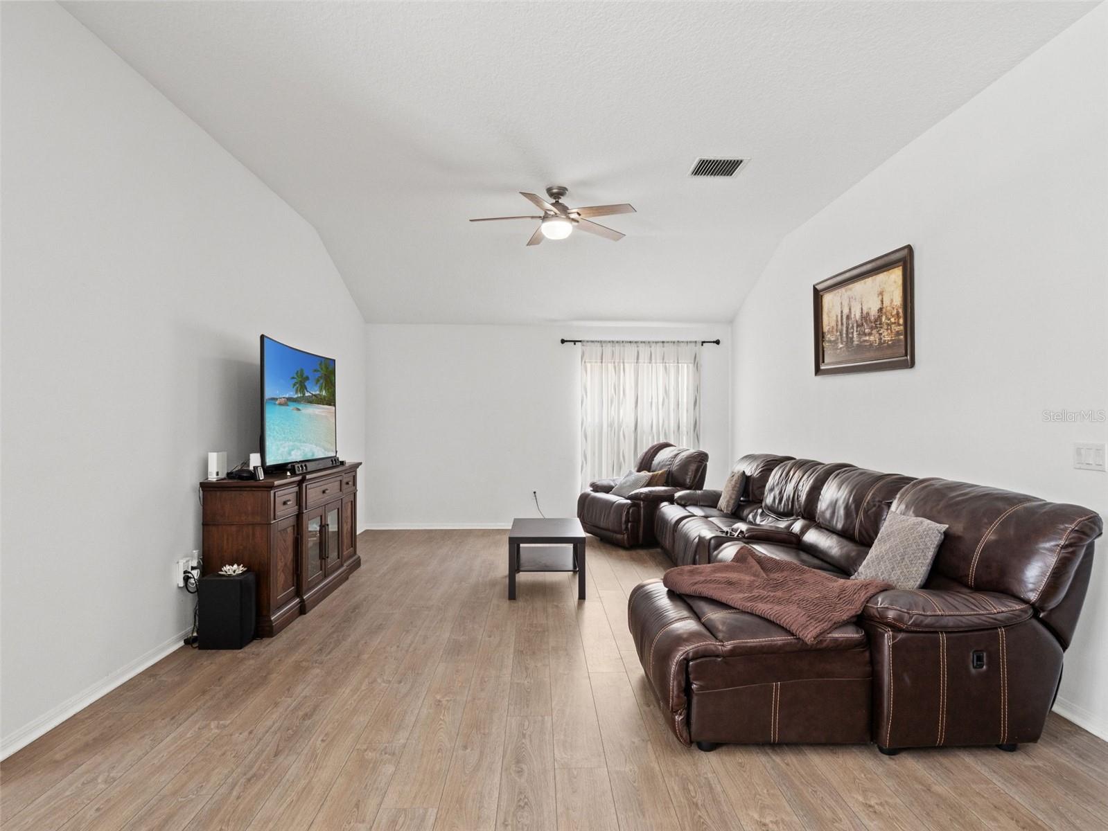 Large secondary living space with vaulted ceilings and plenty of natural light, perfect for a media room, lounge, or flexible use.