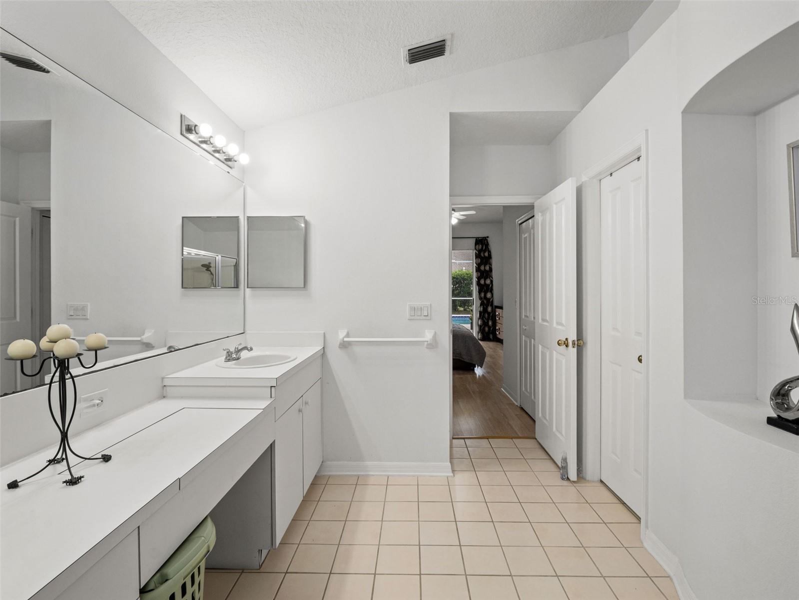Well-appointed primary bath featuring extended vanity area, abundant storage, and a private layout connecting seamlessly to the bedroom.