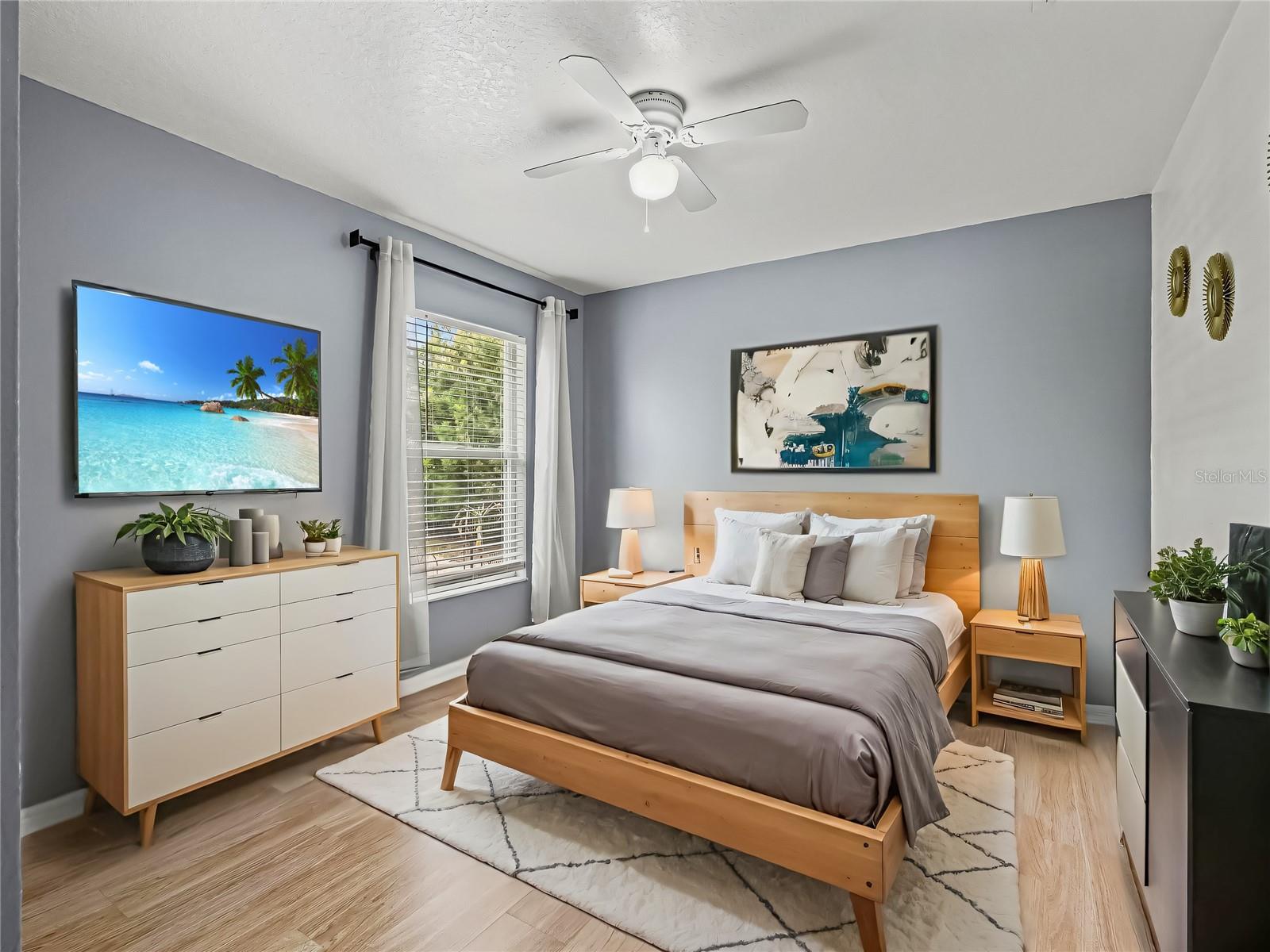 Well-proportioned bedroom with a large window, stylish furnishings, and a soothing color palette, creating a comfortable retreat.