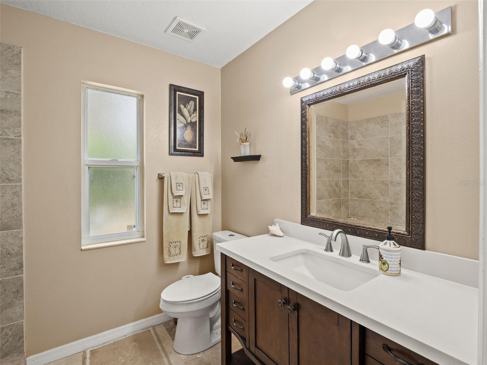 Well-appointed bath with ample counter space, contemporary lighting, and warm neutral tones for a clean, inviting feel.