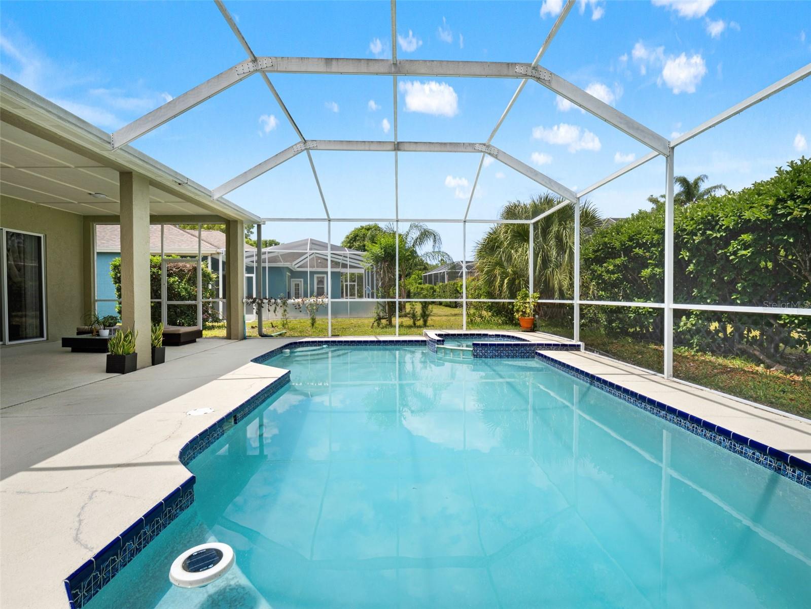 Bright and airy pool area showcasing the home’s rear elevation and covered lanai, ideal for outdoor gatherings.