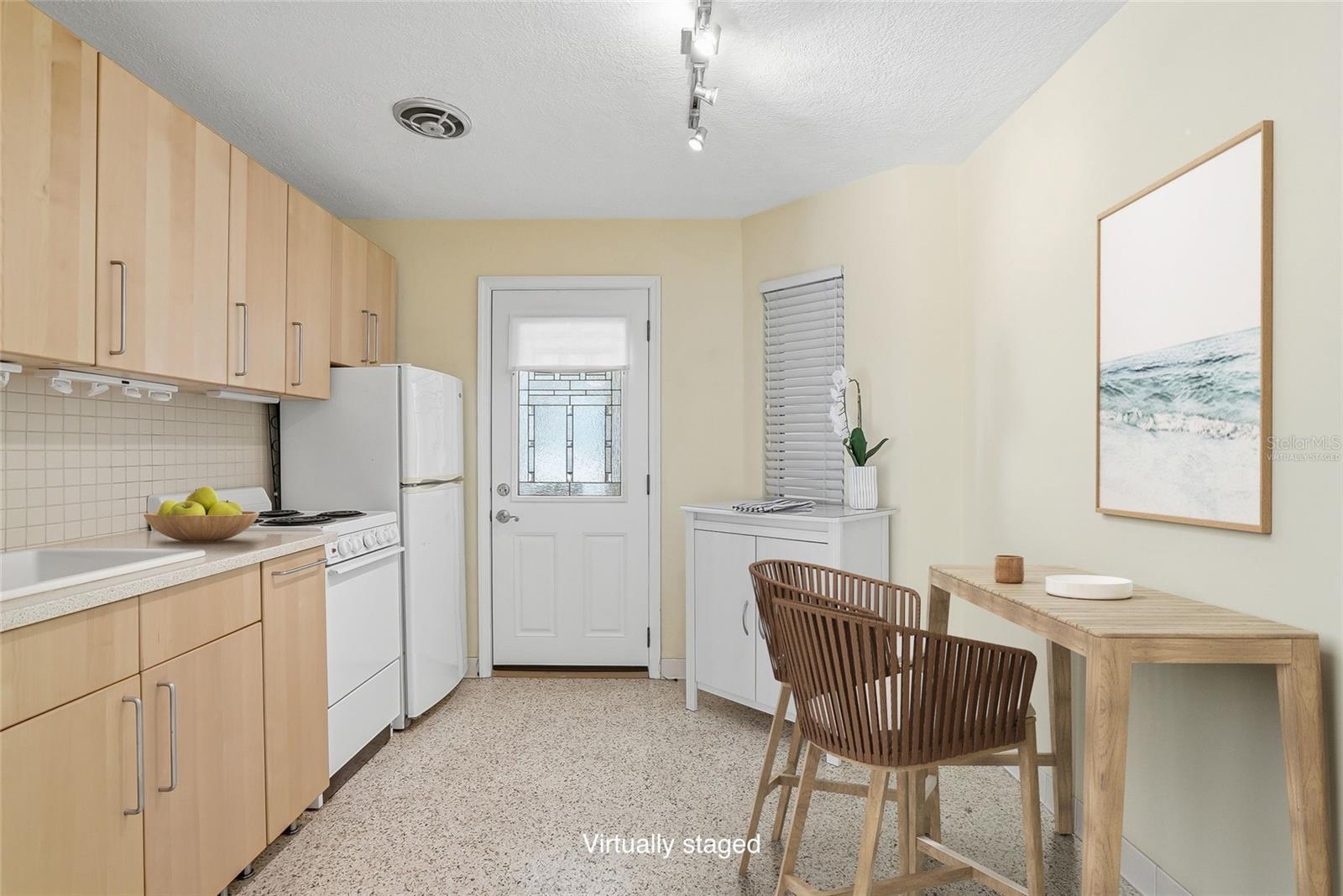 Virtually staged kitchen with secondary door entrance making groceries and deliveries a breeze.