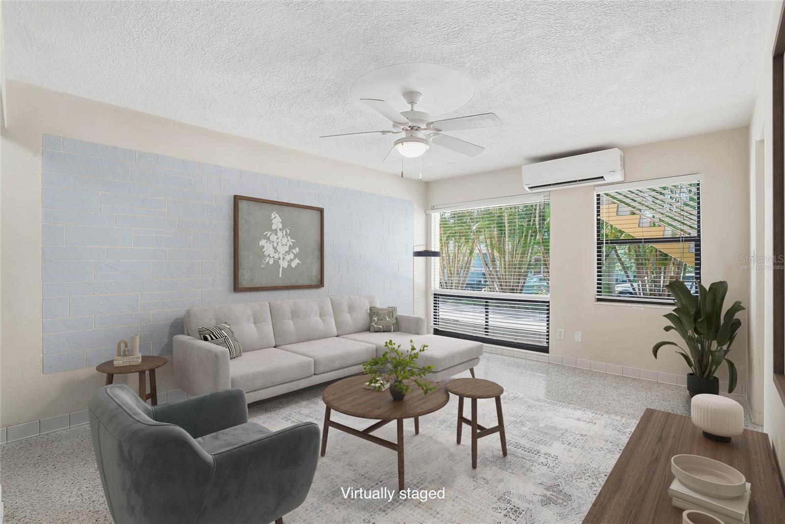 Virtually staged living room with large picture windows and mini split AC system.
