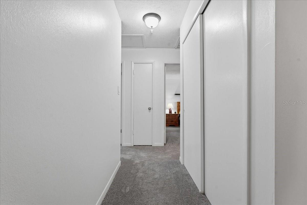 Hallway with storage closet on right side of frame and linen closet straight ahead
