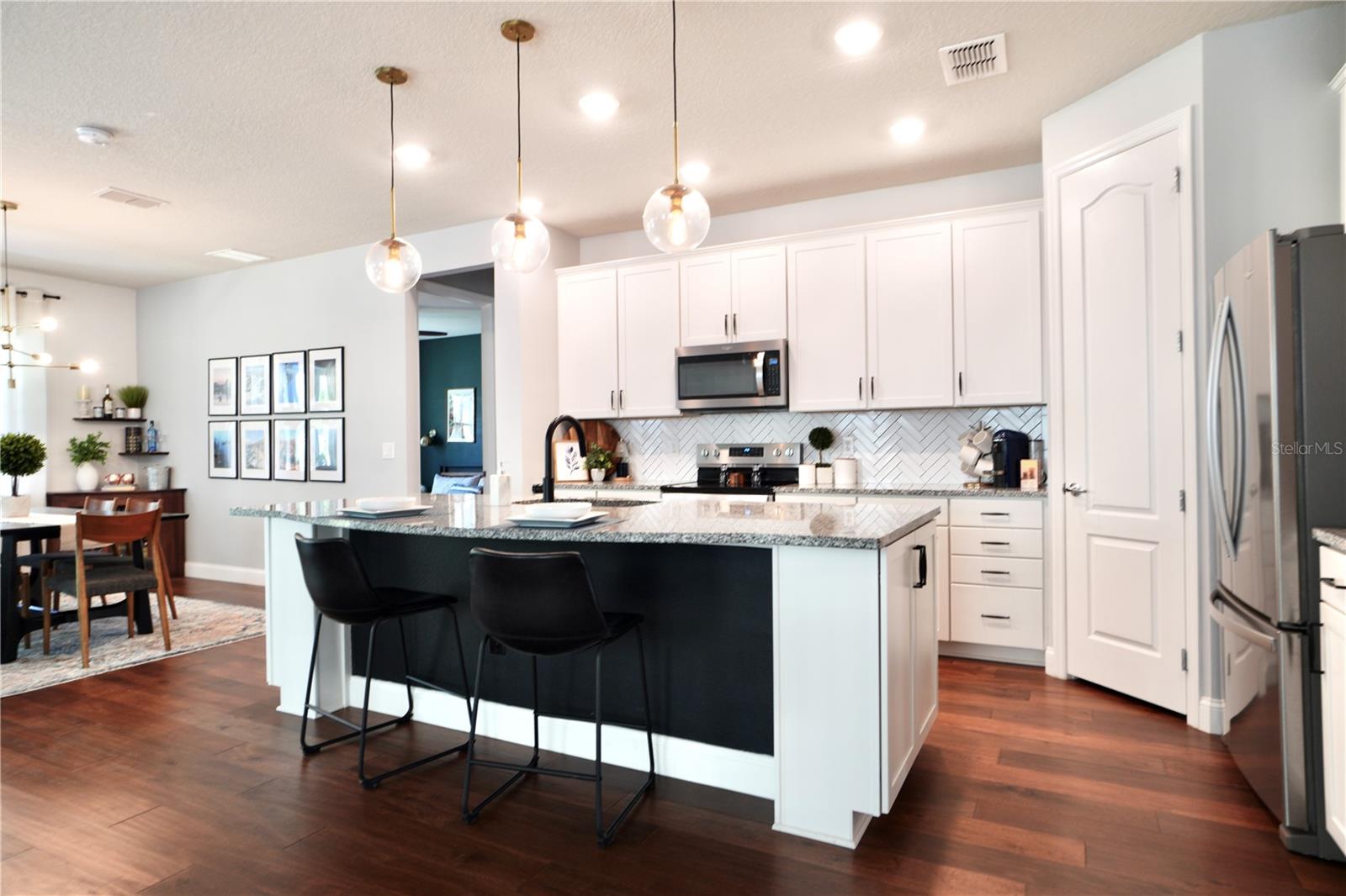 Pendant lighting above the island and an abundance of flush mount lighting.