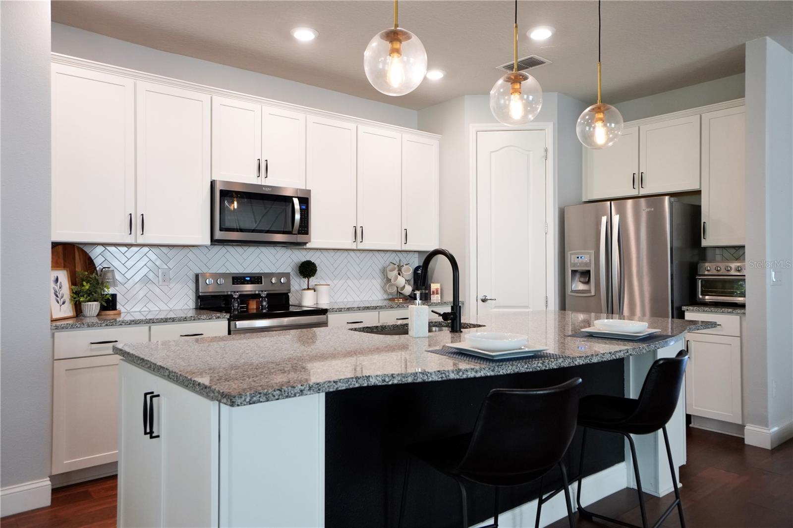 Walk-in corner pantry, backsplash, upgraded faucet and cabinet hardware.