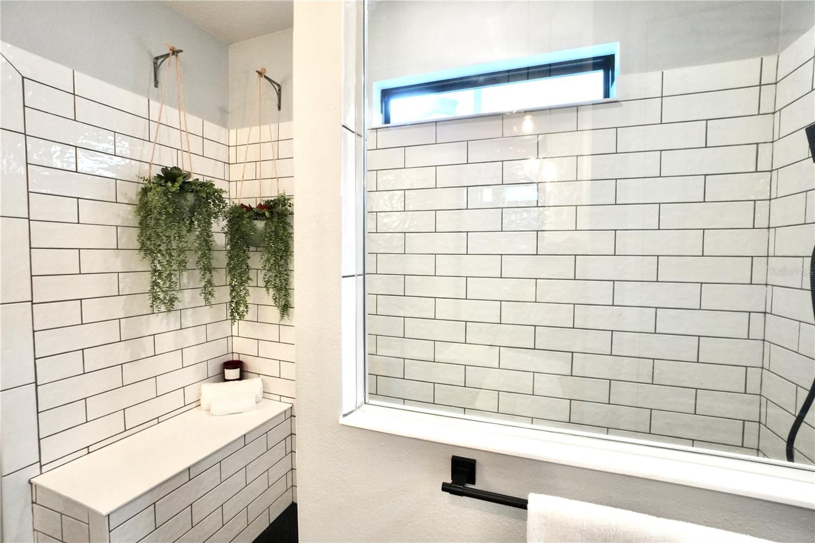 Built-in shower bench with frameless glass enclosure.