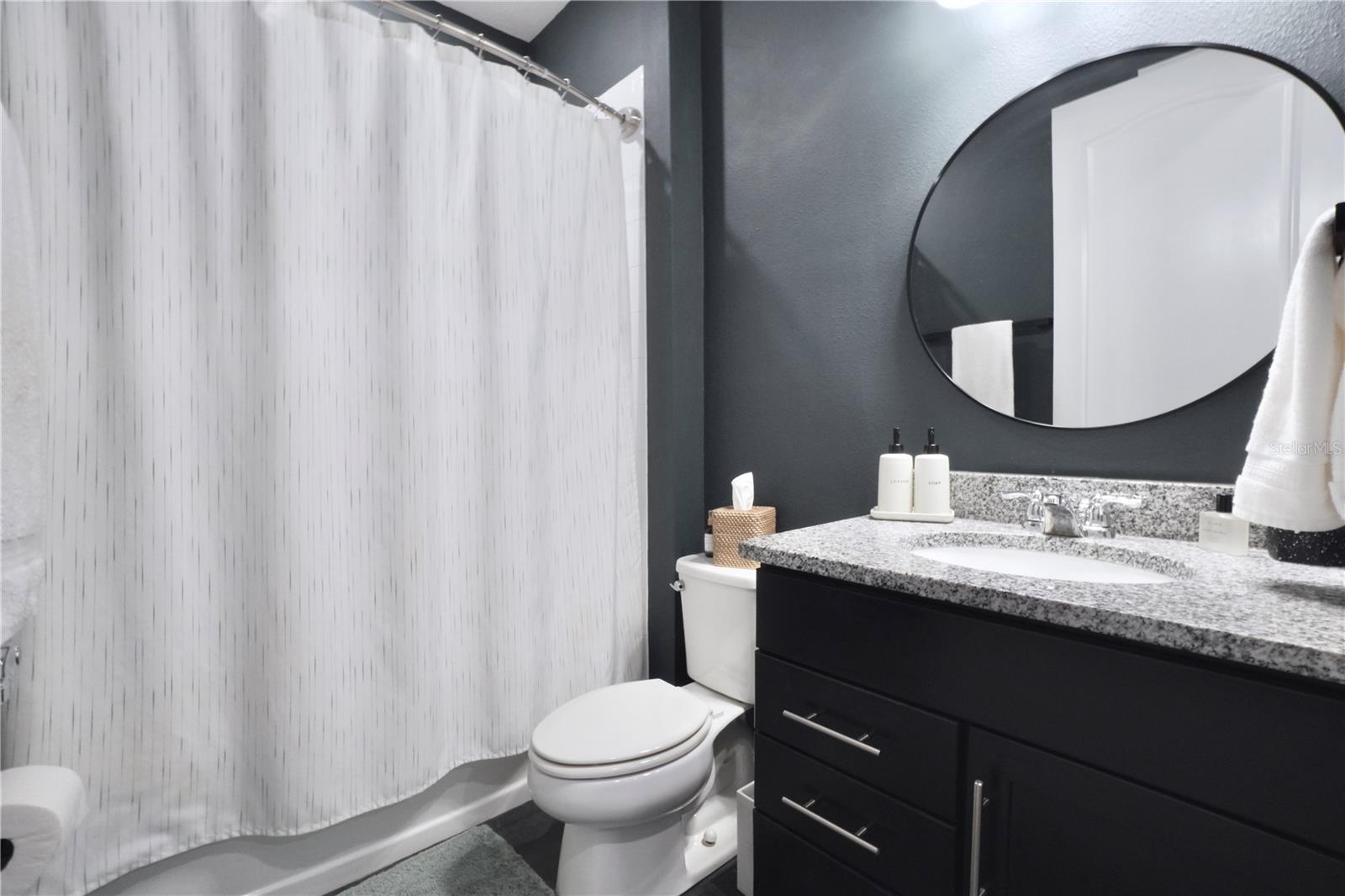 Bathroom 2, with tile floor and extended height vanity with granite countertop.