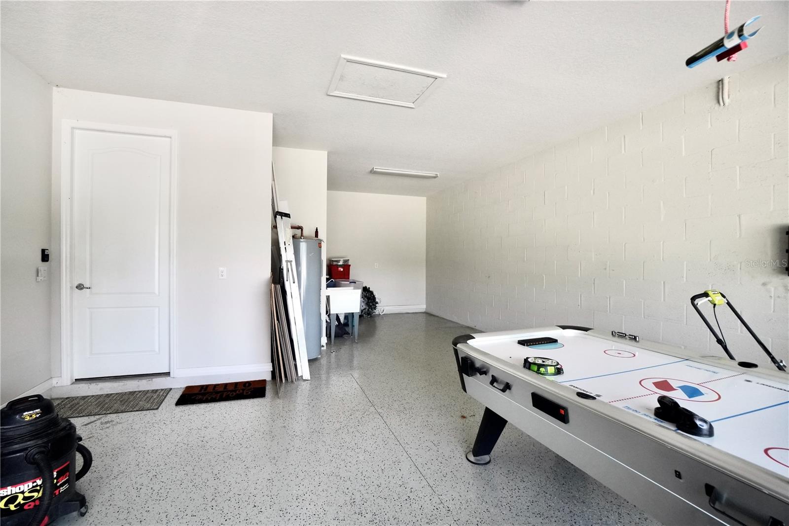 Oversized 2 car garage with epoxy floor and extended tandem space, adding additional storage, or use for workout space or hobby area.