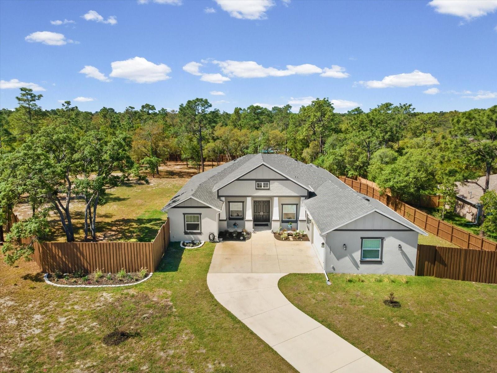 New construction luxury home, custom built home for sale, move in ready luxury home, 5 bedroom home with acreage, Florida luxury real estate, Brooksville FL homes for sale, Spring Hill FL luxury home, Hernando County new construction, open concept luxury home, coffered ceilings, oversized sliding glass doors, eat in kitchen with granite island, Viking propane cooktop, double oven kitchen, oversized walk in pantry, climate controlled garage, in law suite with ensuite bath, zero entry walk in shower, spa like primary bathroom, home on 1.27 acres, fully fenced property, private acreage home, covered outdoor patio, outdoor kitchen ready, room for pool and spa, generator ready home, buried propane tank, luxury entertainer’s home, high end finishes throughout, multi generational living, private retreat home, custom lifestyle home,