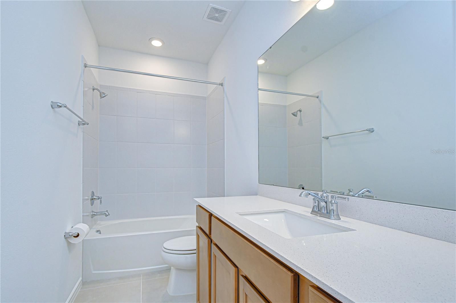 Convenient full bath with quartz counters and upgraded fixtures