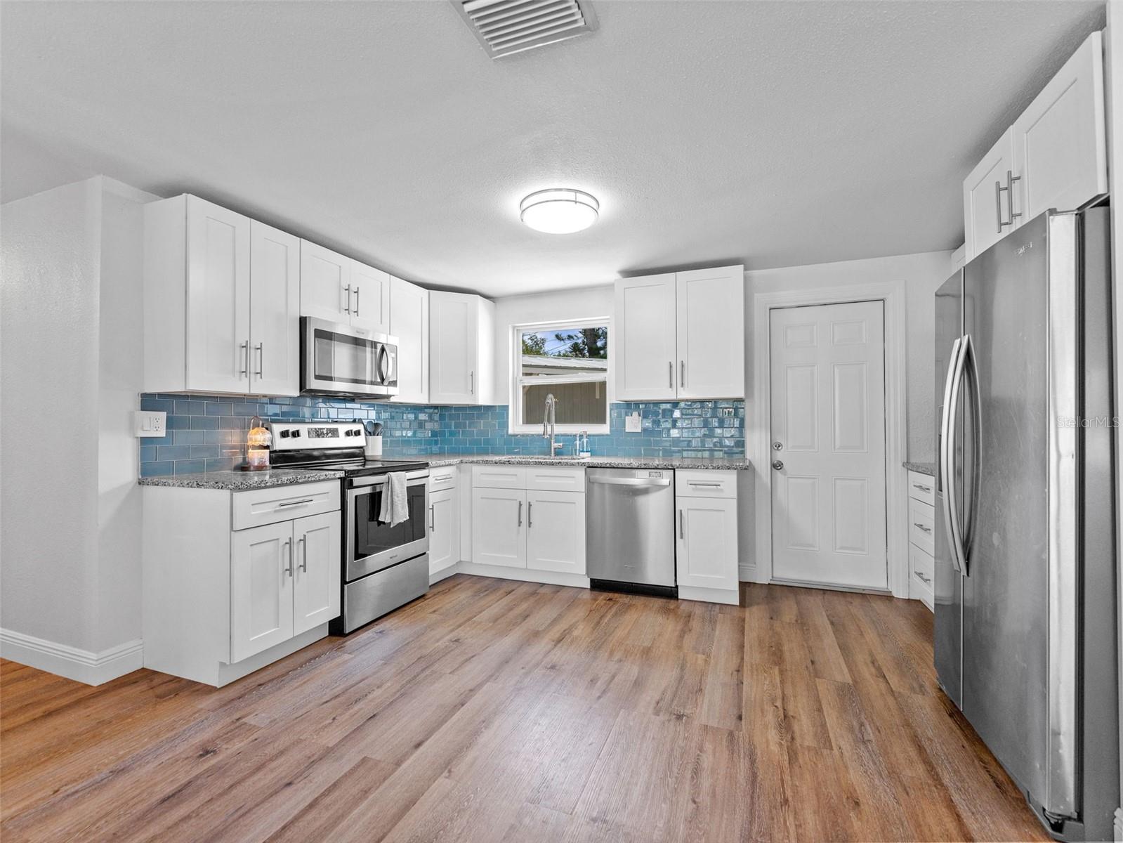 Kitchen features all stainless steel whirlpool appliances