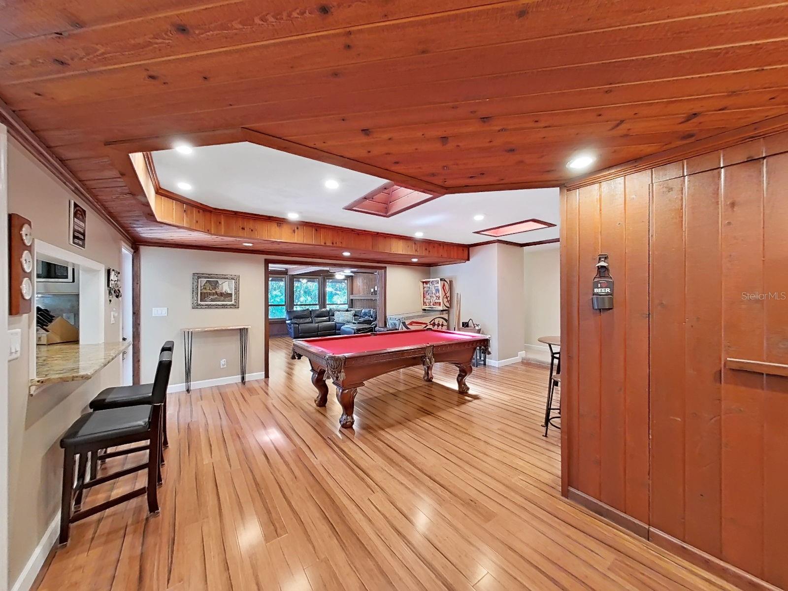 This impressive Bonus Game Room sits adjacent to the Kitchen with a pass-through bar. The Florida Family Room is in the distance. Grab your pool stick... The pool table conveys with the home!