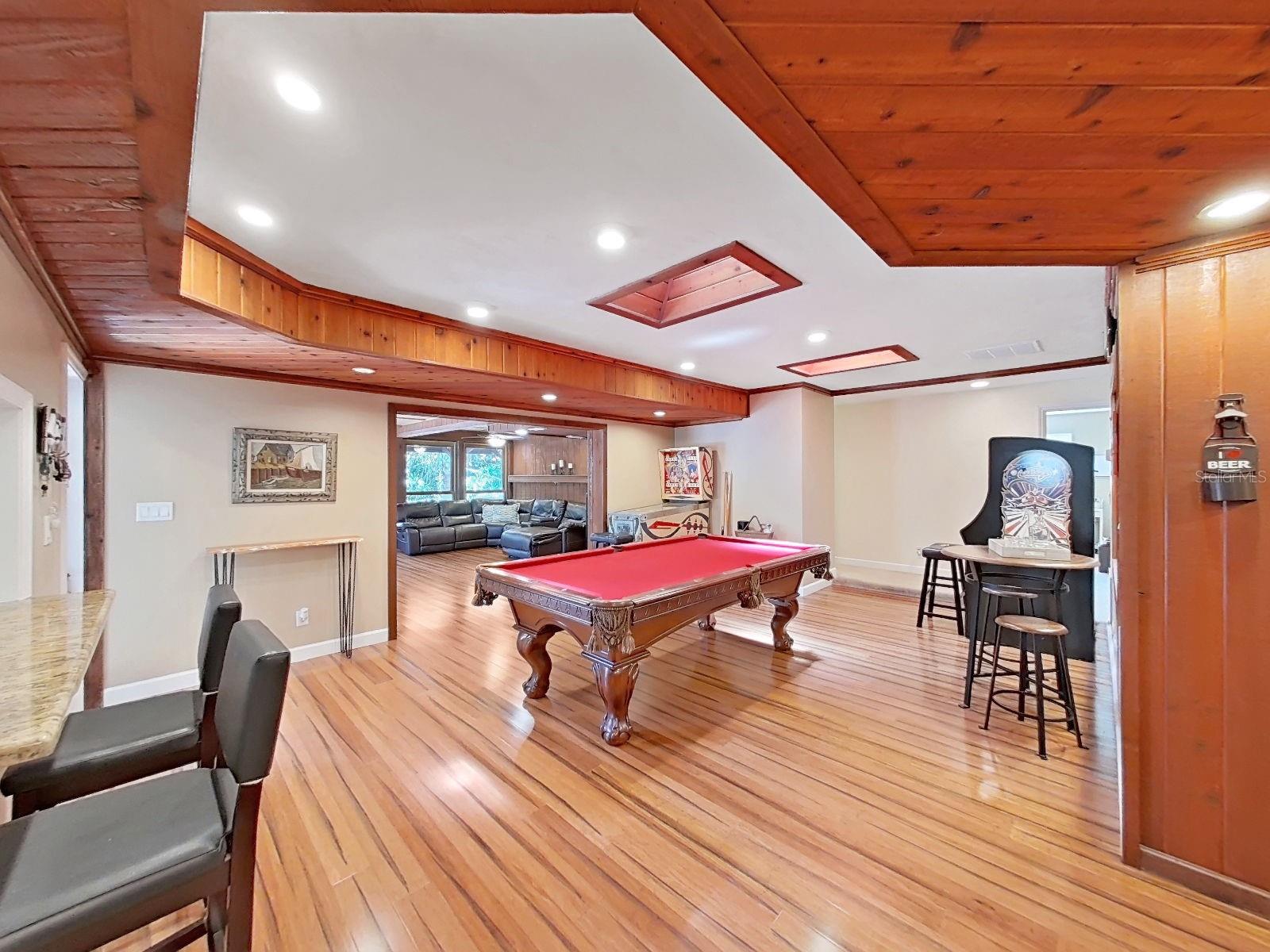 The grand Bonus Room with skylights & warm wood details. Open flow into the adjacent Florida Family Room.