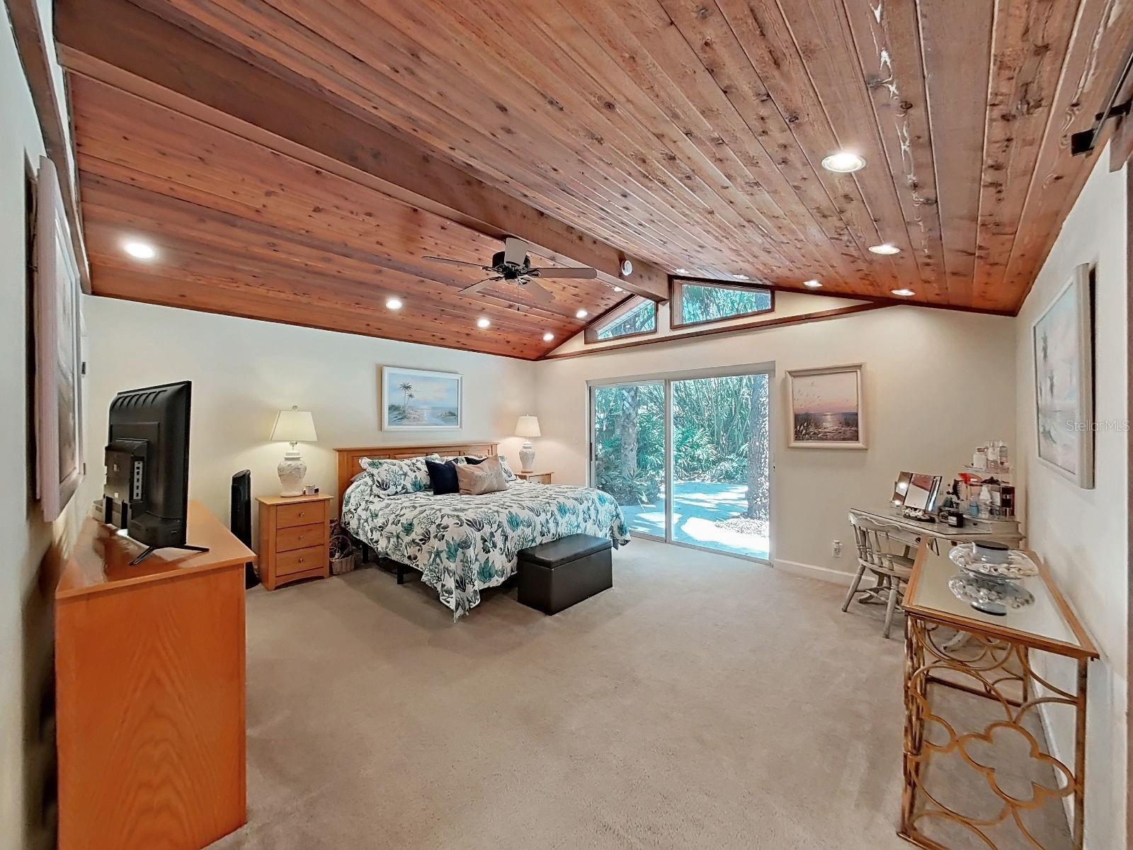 Primary Suite with vaulted wood ceiling, slider to the backyard, & a bright, spacious layout that feels like a luxury retreat!