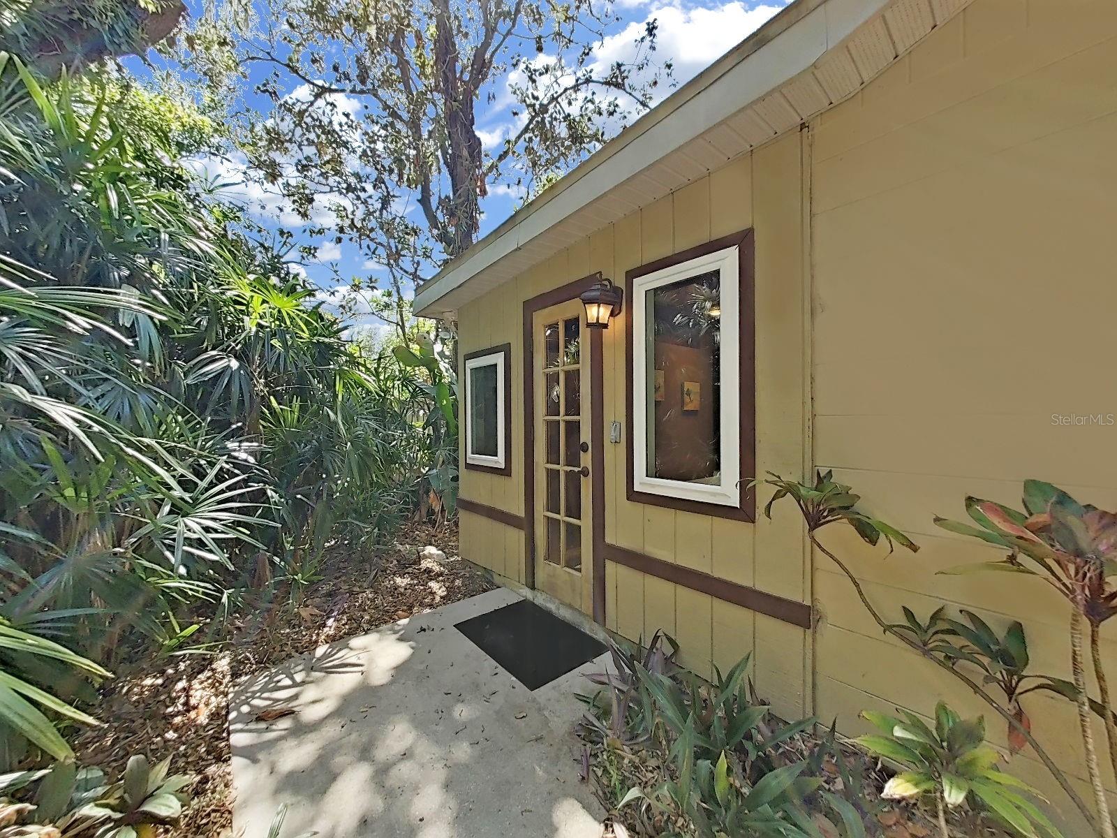 Private backyard access from the Primary Bathroom, surrounded by lush tropical landscaping. Leads to the jacuzzi & backyard living. A lovely access that makes you feel like you're at a resort!