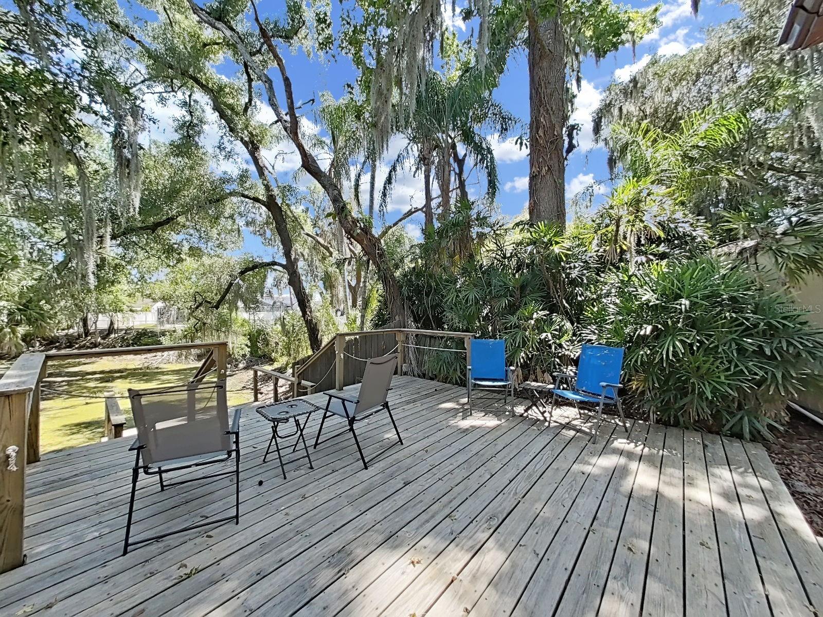 Peaceful wood deck and dock tucked among lush greenery. Perfect place to sip morning coffee or unwind with friends at the end of the day.