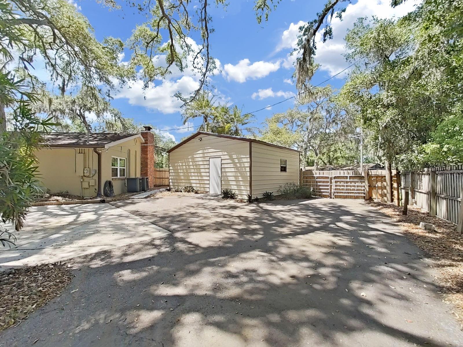 Rear entry of the detached 2-Car Garage, plus the adjacent paved spot specifically designed for RV storage (with 50-amp plug service for hooking up).