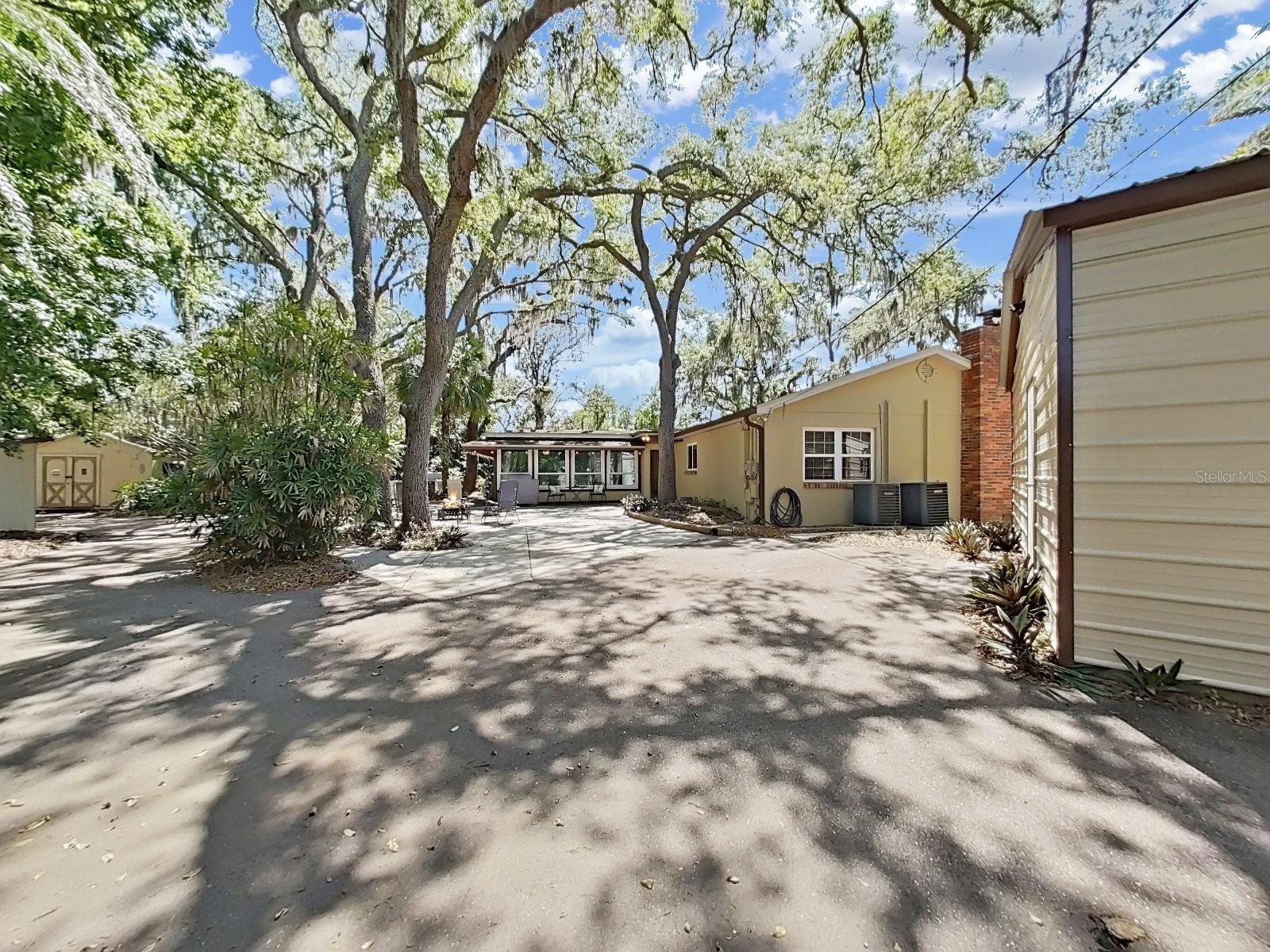 Outdoor living and a true dream backyard with a sprawling paved courtyard. RV parking with hookup, detached 2-Car Garage, insulated hangout shed in the distance, and versatile patio for outdoor living (perhaps an above ground pool for dipping on a hot day).