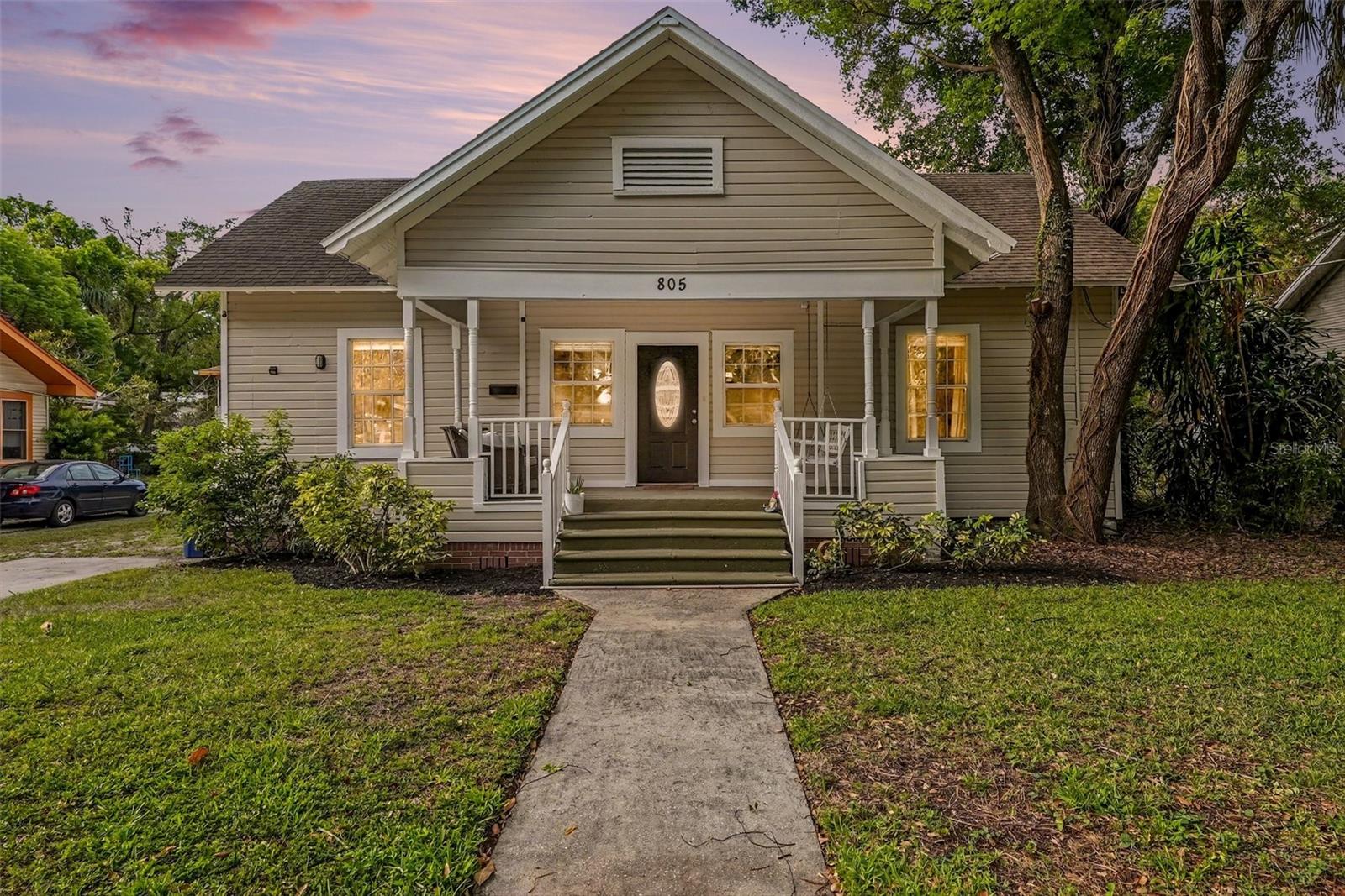 Twilight exterior showcasing inviting curb appeal and front porch.