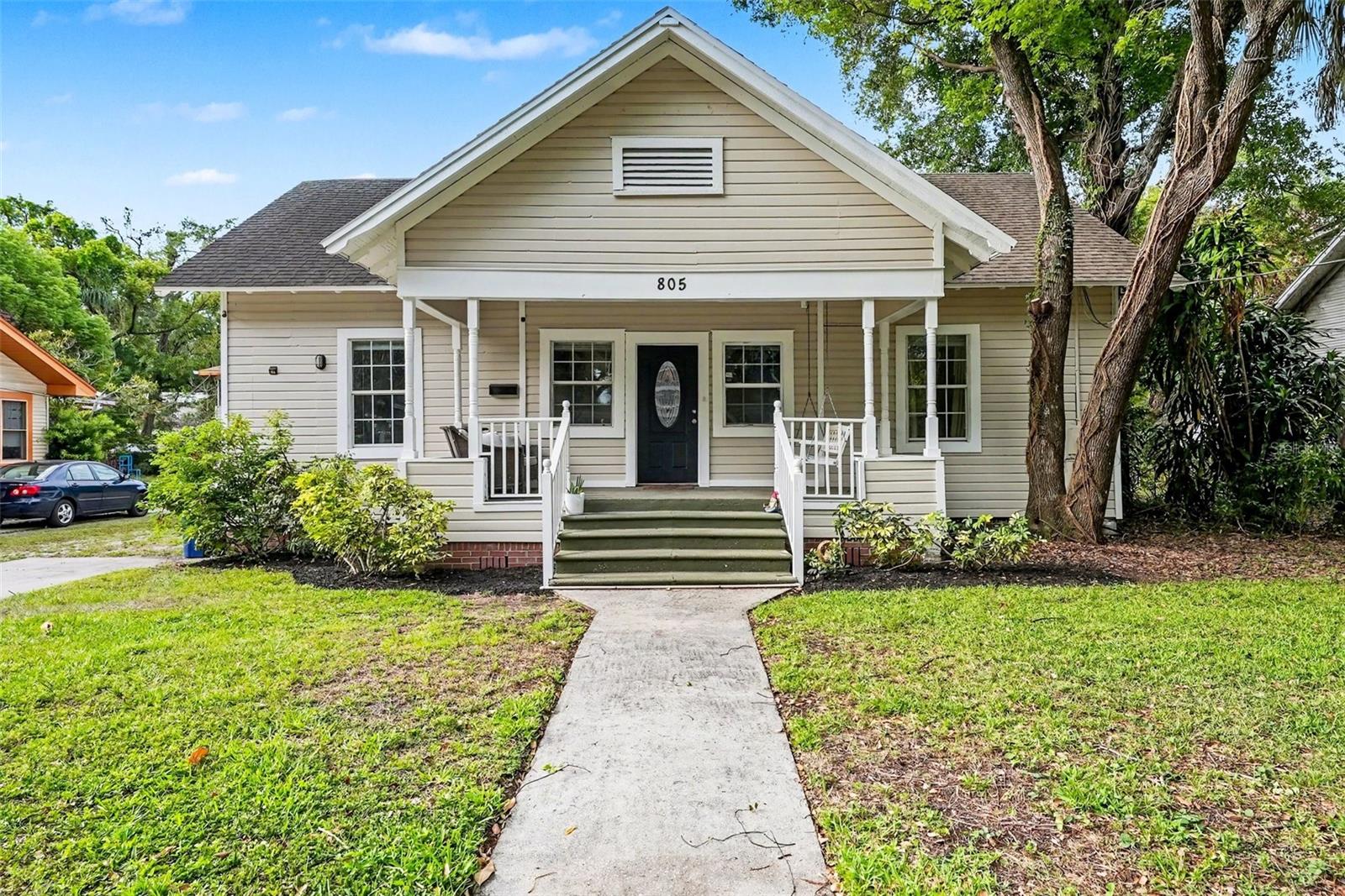 Front exterior with classic bungalow charm and mature landscaping.