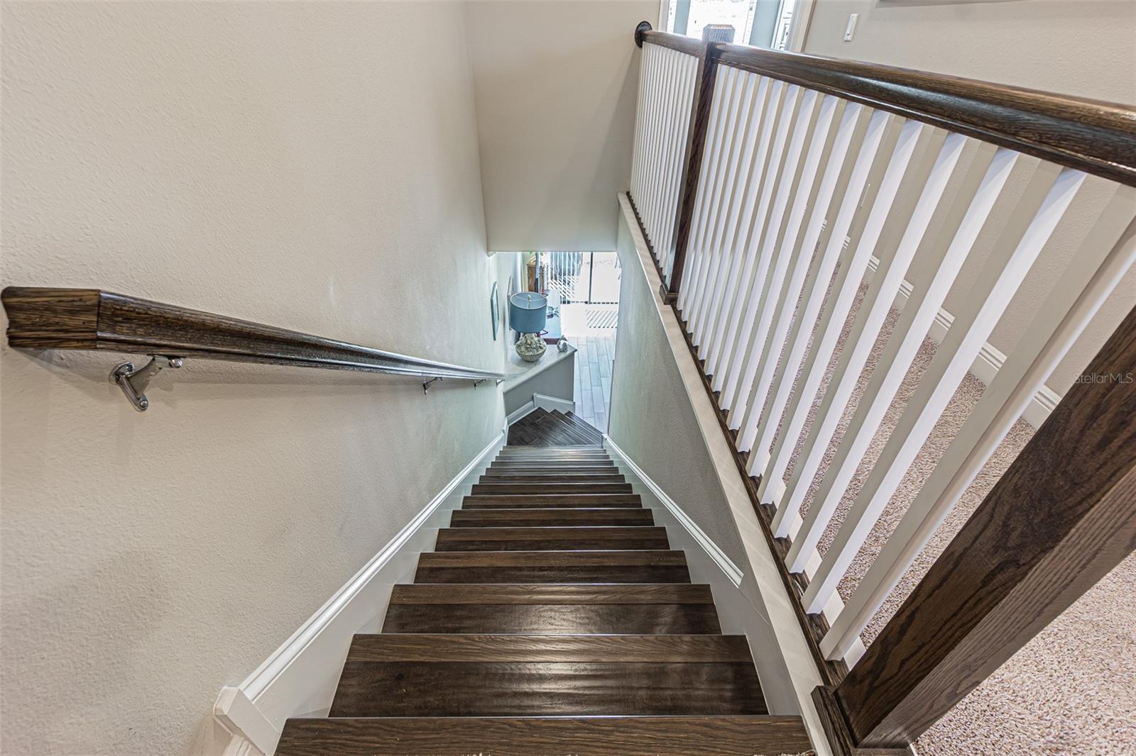 Wood stairs down to the main living area.