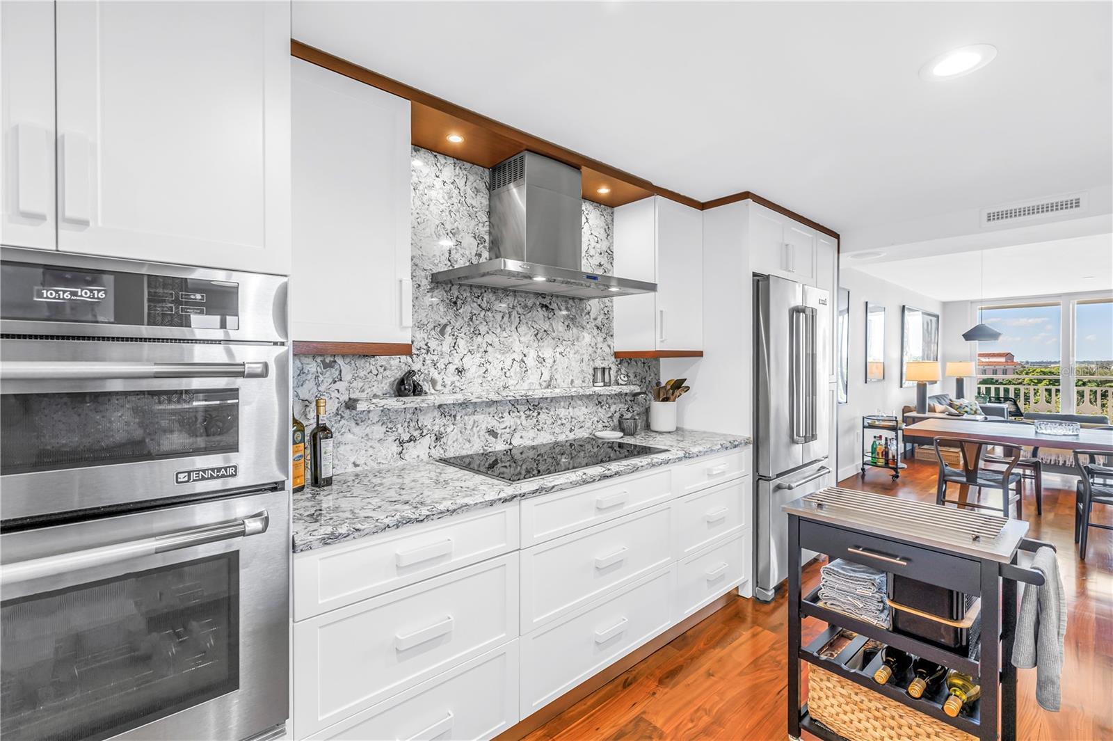 Microwave, Induction cooktop with ventilation hood and French door refrigerator - JennAir stainless steel appliances