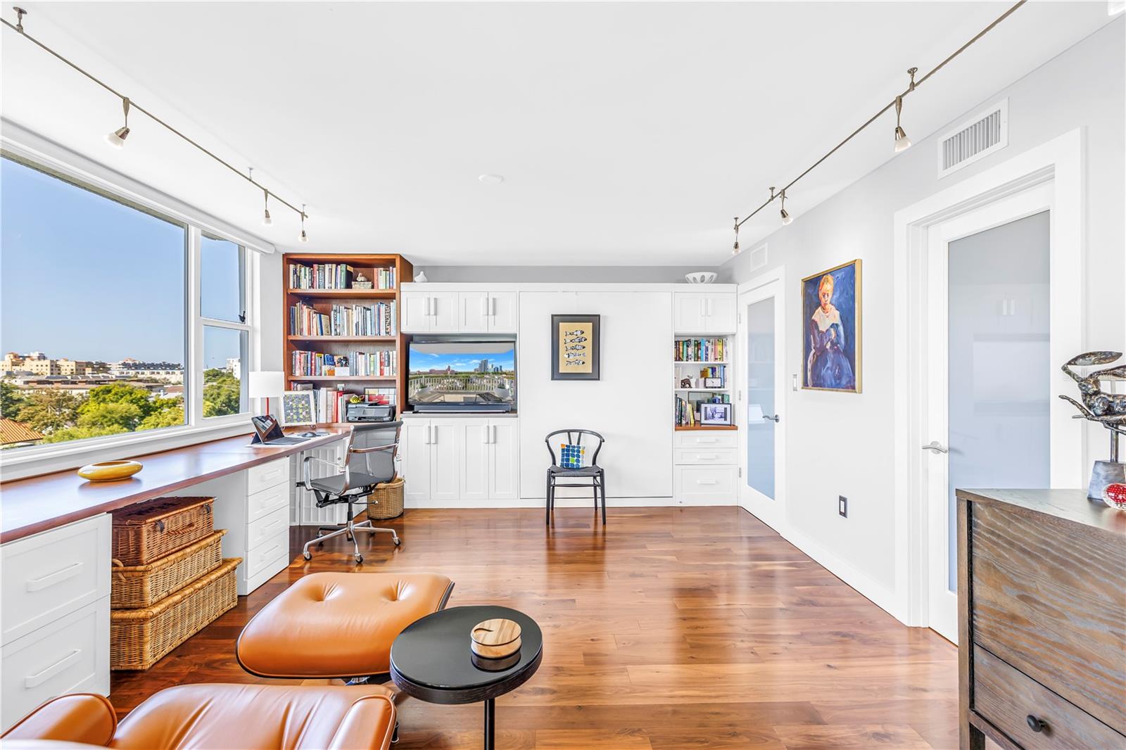 2nd or guest bedroom, also, doubles as den or office with 2 desk areas, book shelve and "feather-light Murphy Bed (behind the chair on the west wall). Bathroom and laundry room are behind the doors on the right