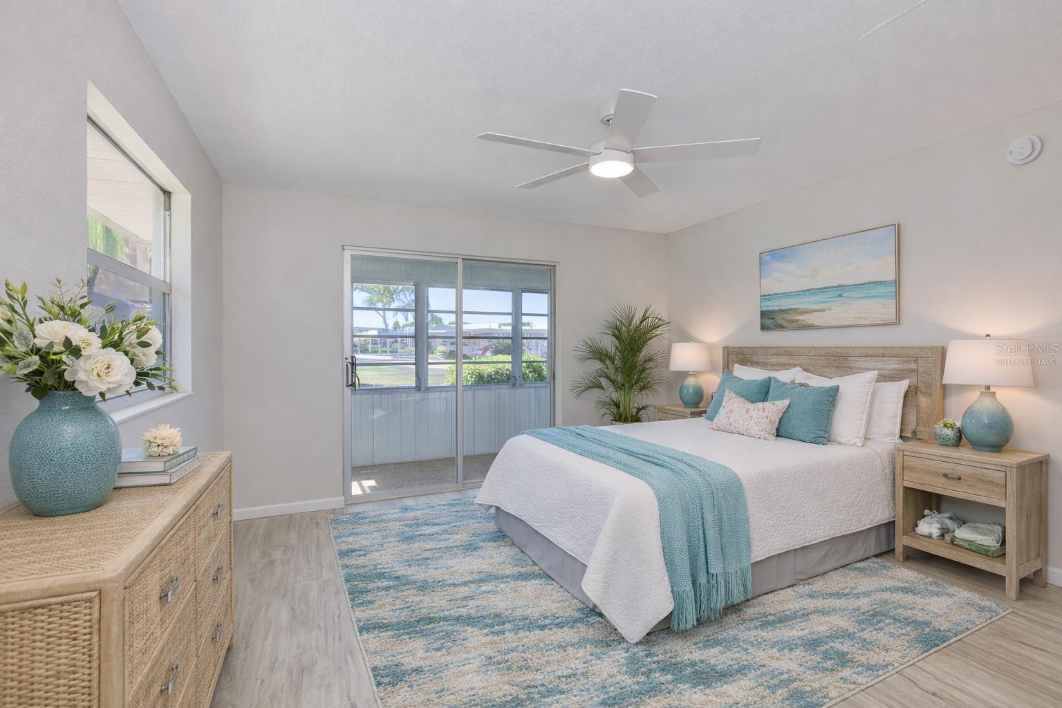 virtually staged 2nd bedroom with glass sliders leading to the enclosed lanai