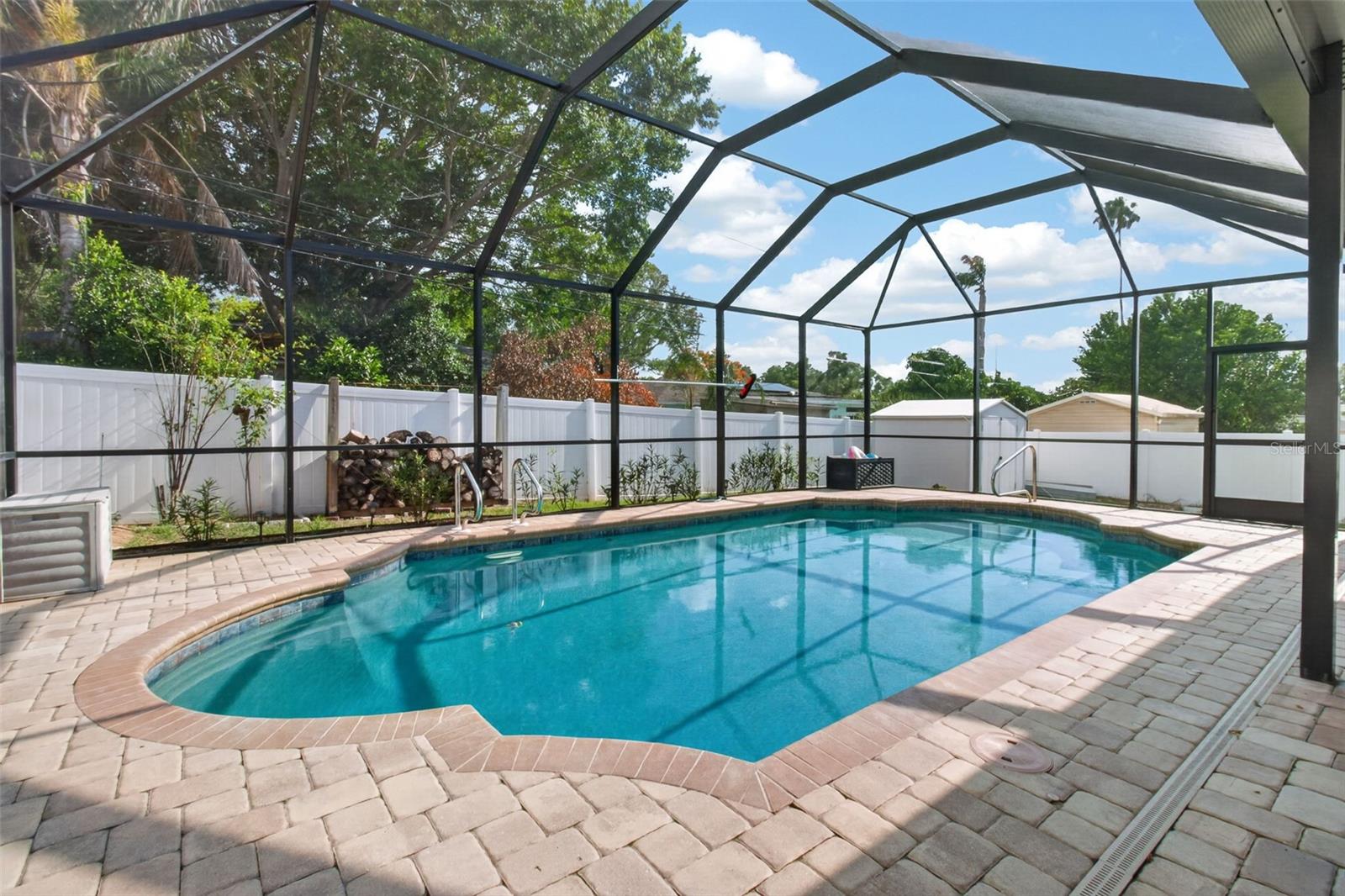 Heated salt water pool with Robotic Pool Cleaner and Solar Cover is surrounded by paver deck area.