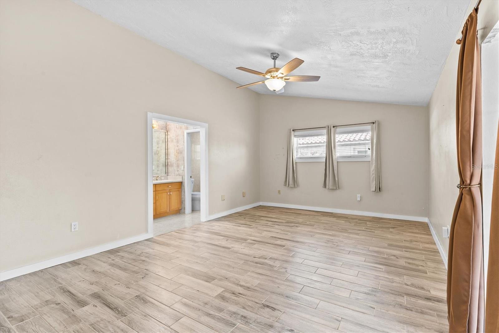 Private primary suite featuring tile floors, direct access to the pool through sliding door, and a well-appointed en suite bath—offering comfort and indoor-outdoor living