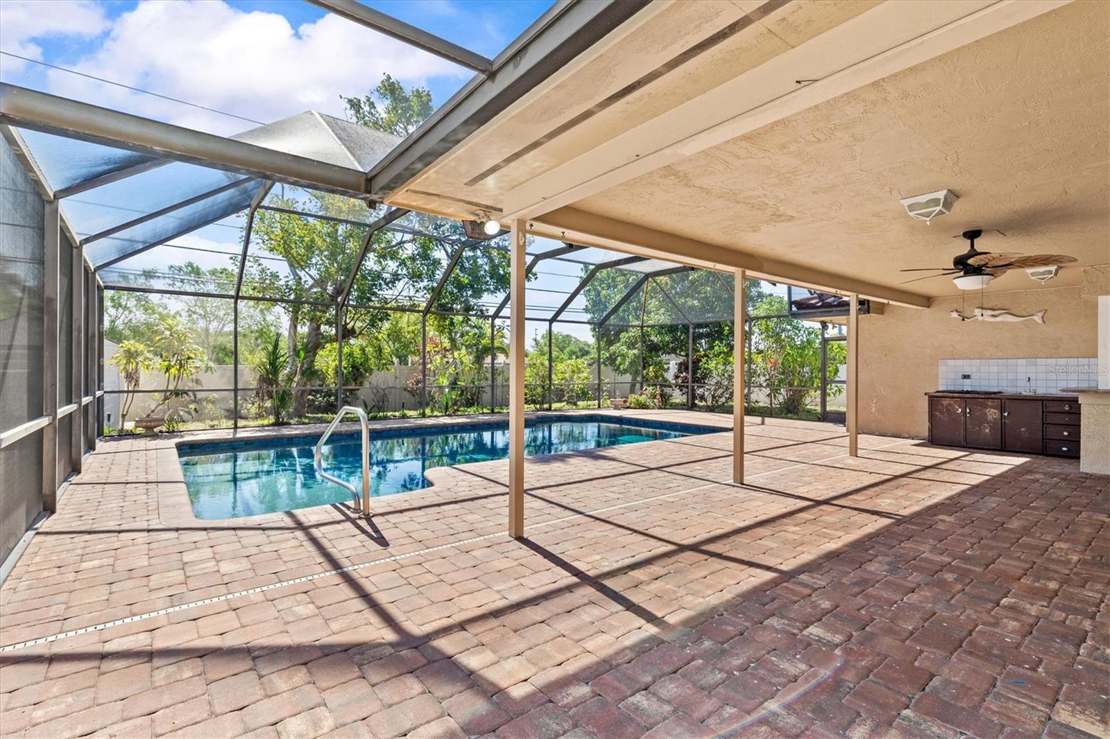 Screened-in pool with covered outdoor living area—perfect for relaxing, dining, and enjoying Florida living in comfort.