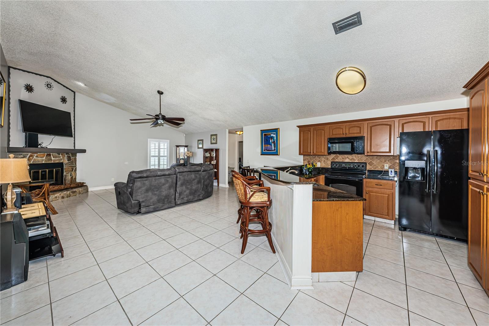 Kitchen opens onto family room with fireplace