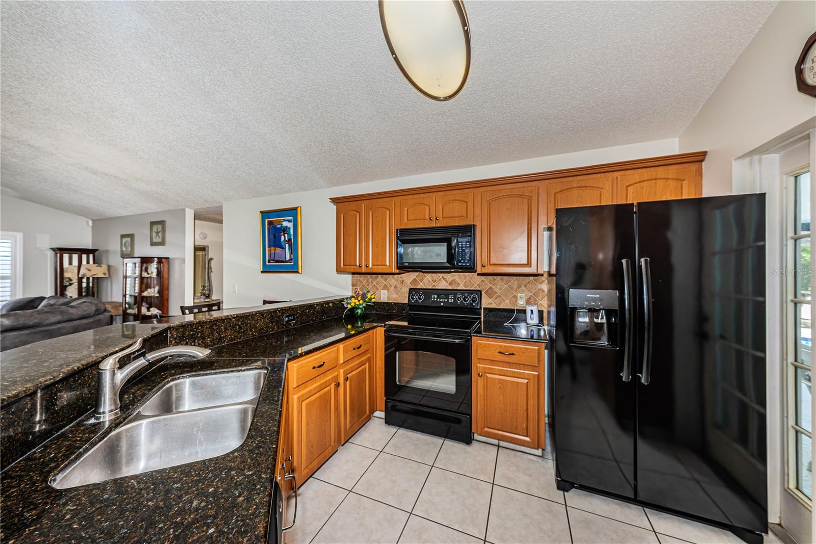Open kitchen with snack bar and door to the pool.