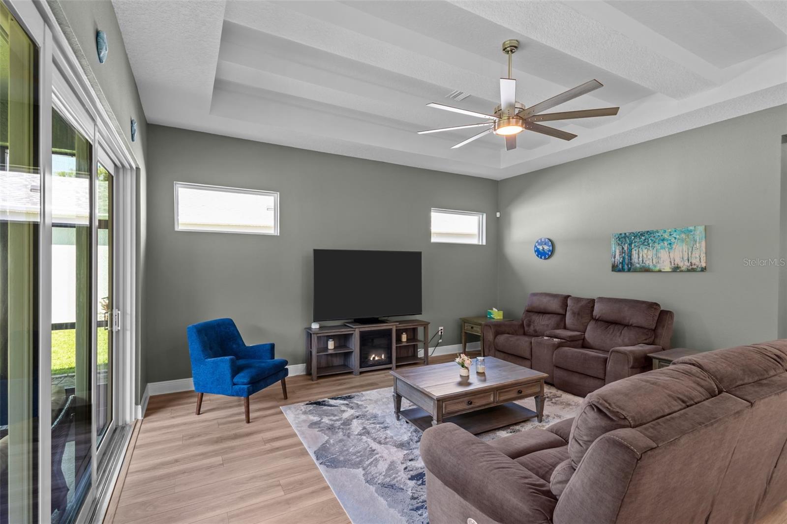 Spacious living room with high ceilings, tray detail, and decorative beam accents.