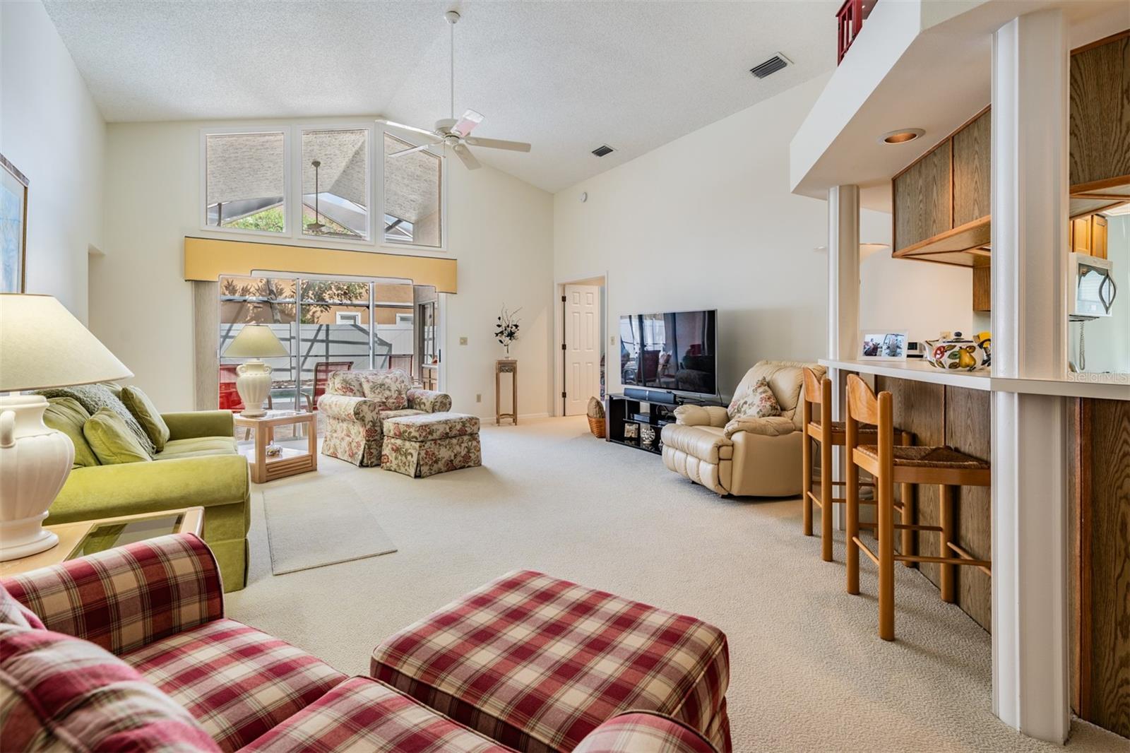 Spacious Family Room with Vaulted Ceilings, lots of sunlight and a ceiling fan.