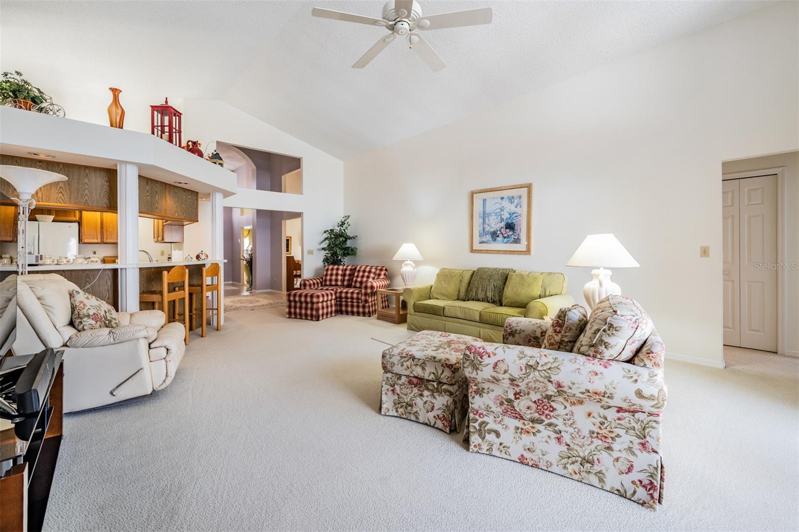 Spacious Family Room with Vaulted Ceilings, lots of sunlight and a ceiling fan.
