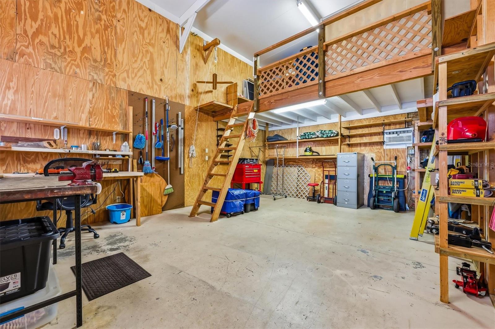 Large workshop with loft for storage, and pulley lift to bring things up.  Shelving remains, generator and 17 ft extension ladder can remain.