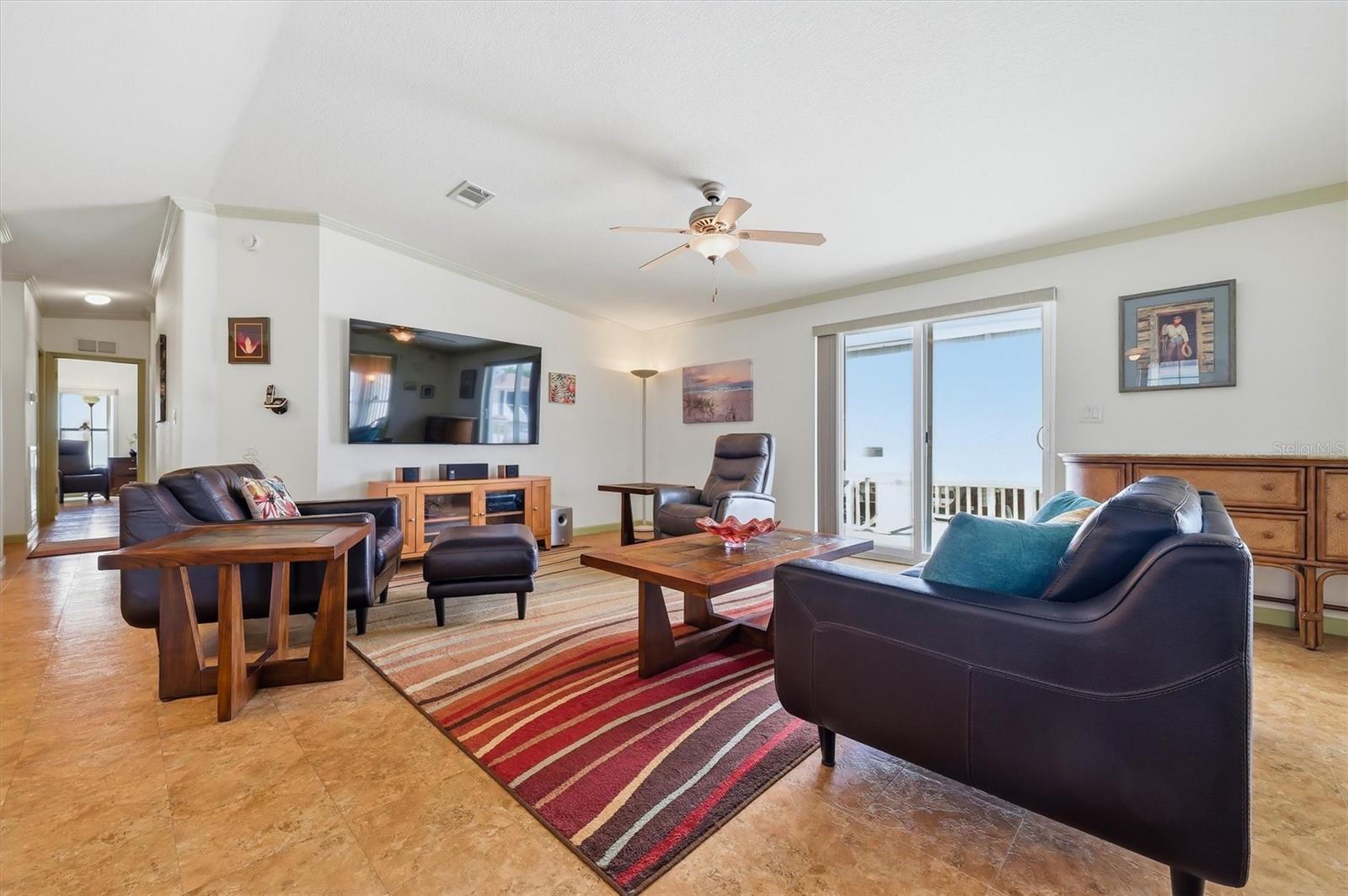 Living Room with sliding doors leading out to the side deck and yard.  Wall tv and stereo system can remain.