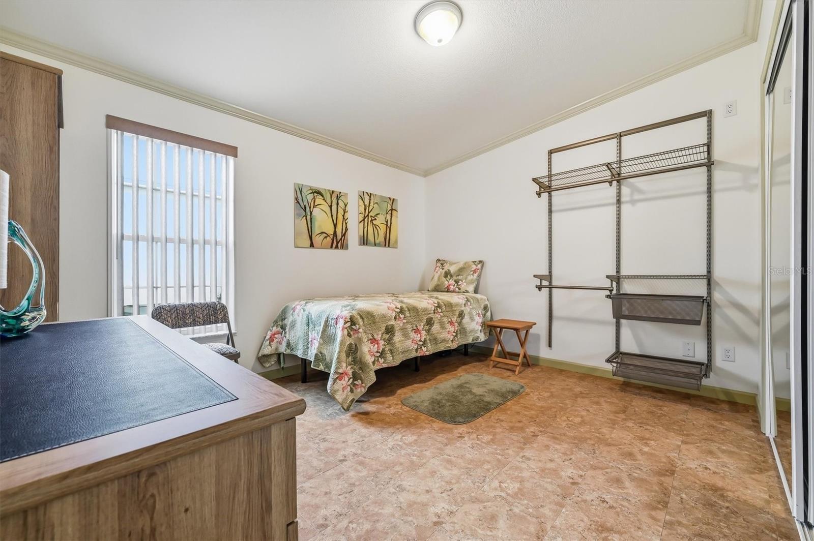 2nd bedroom with large closet and additional wall clothes rack assembly for storage or guests