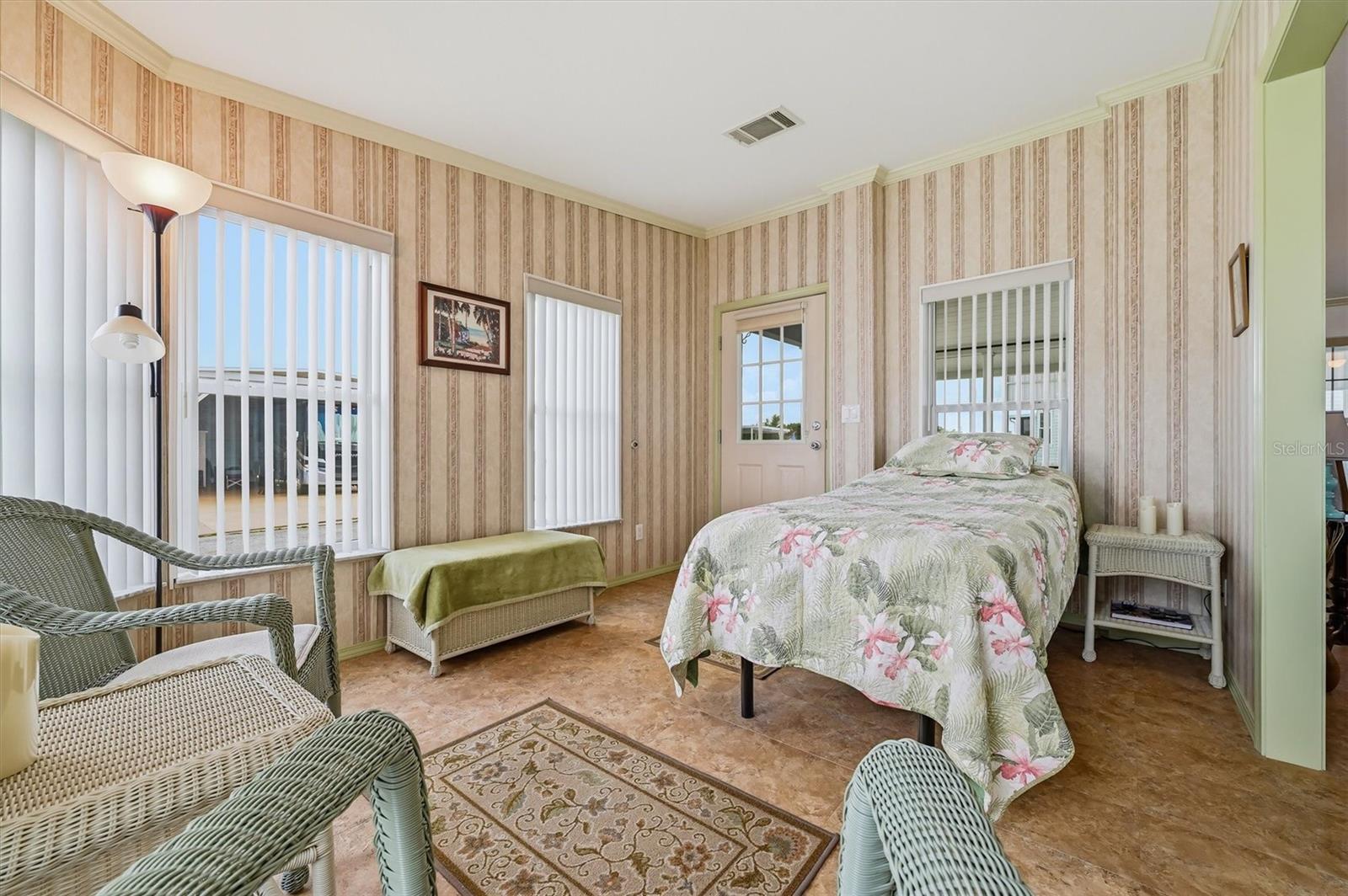Front flex room showing lots of windows and light,  with door entry from carport.