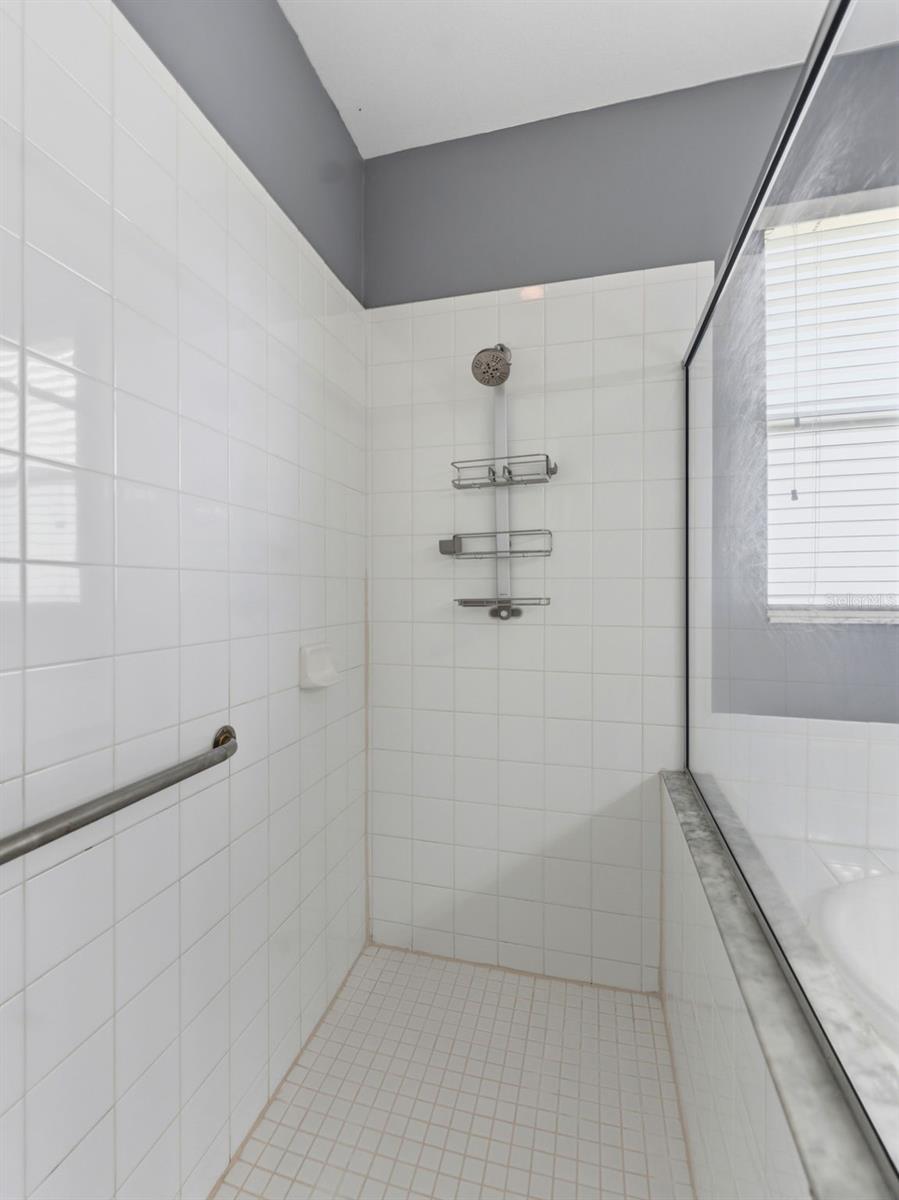 Gleaming white tile in large walk-in shower