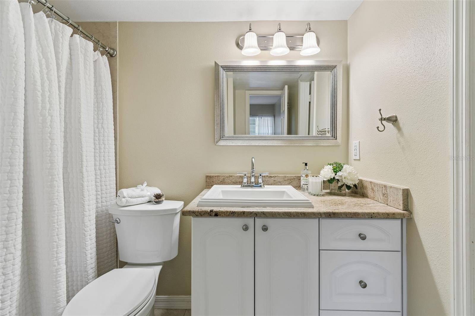 Bathroom with granite countertops and tiled shower