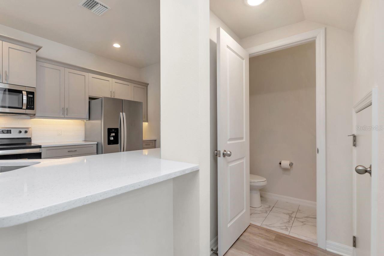View of Half Bath, Kitchen, and storage area under staircase