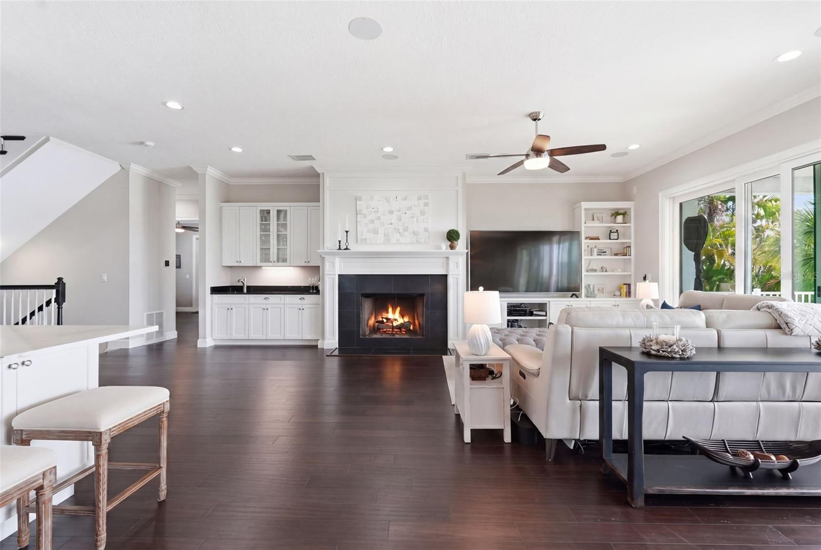 The wood-burning fireplace is a lovely focal point. It is surrounded by custom cabinets, built-ins and trim work. And that's a wet bar to the left. Who's thirsty?