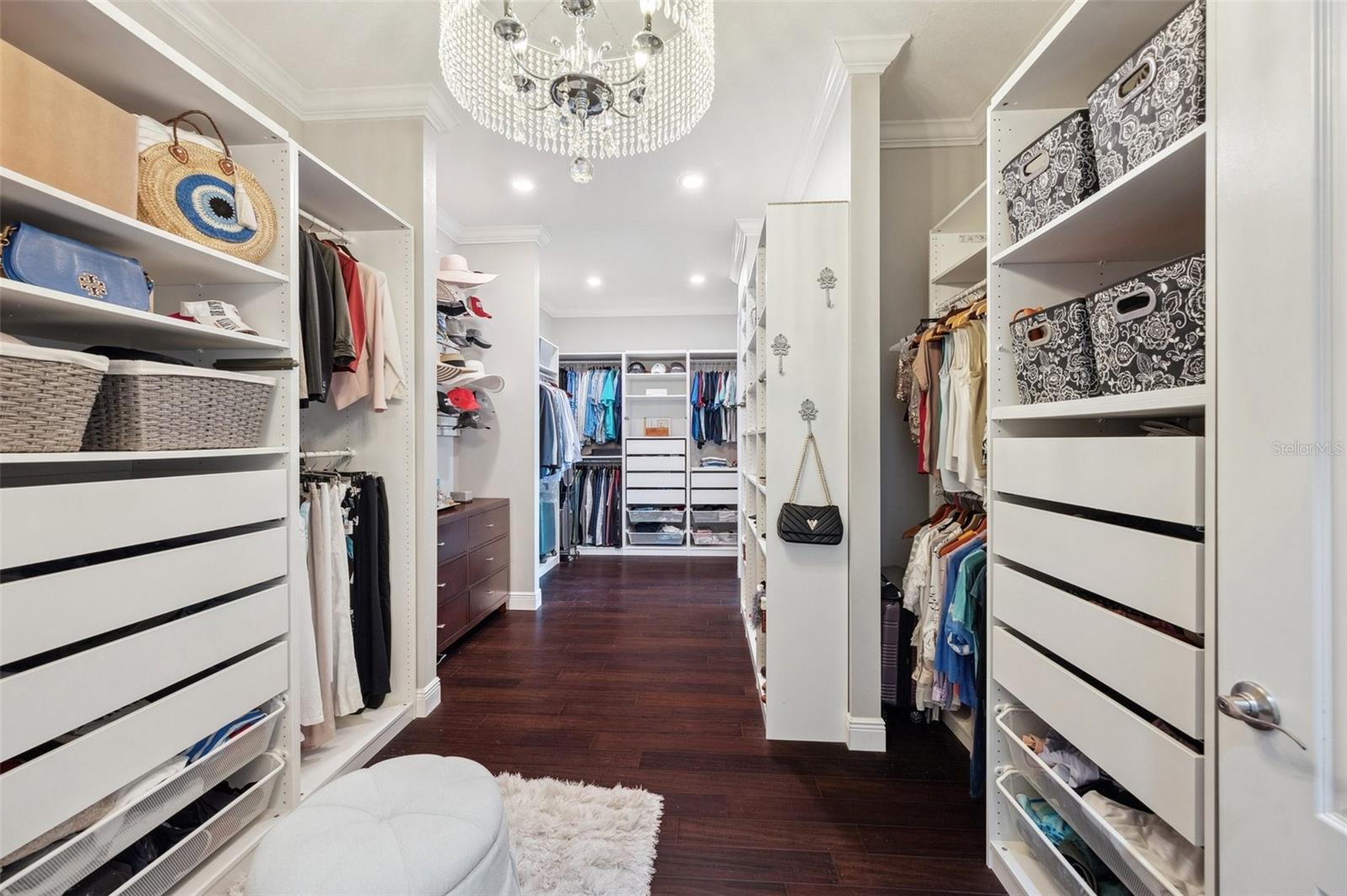 Luxurious walk-in master bedroom closet with elegant crystal chandelier.