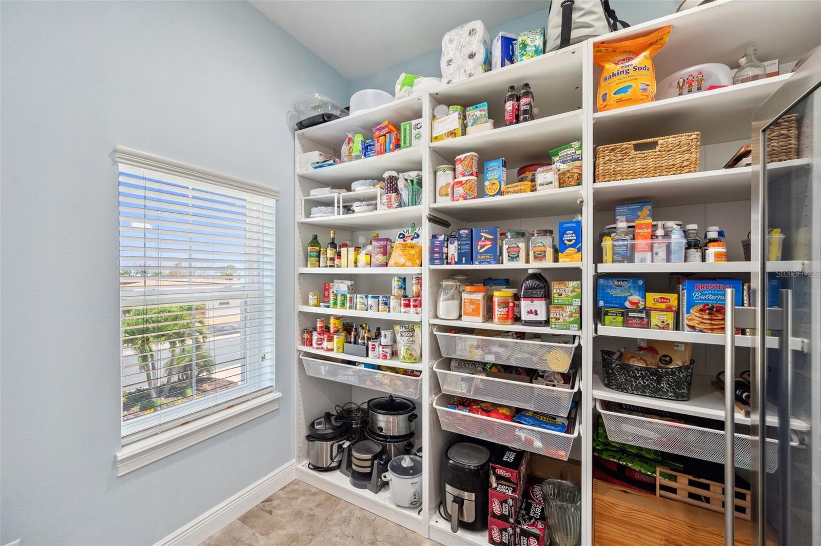 The pantry includes pull out shelves to maximize space and utility.