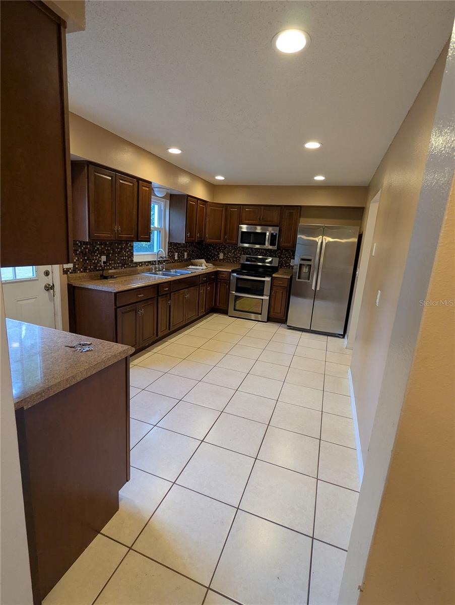 Large Country Kitchen with modern appliances and tiled floor.  kitchen is large enough to accommodate a kitchen table. The large pantry provides great storage!!