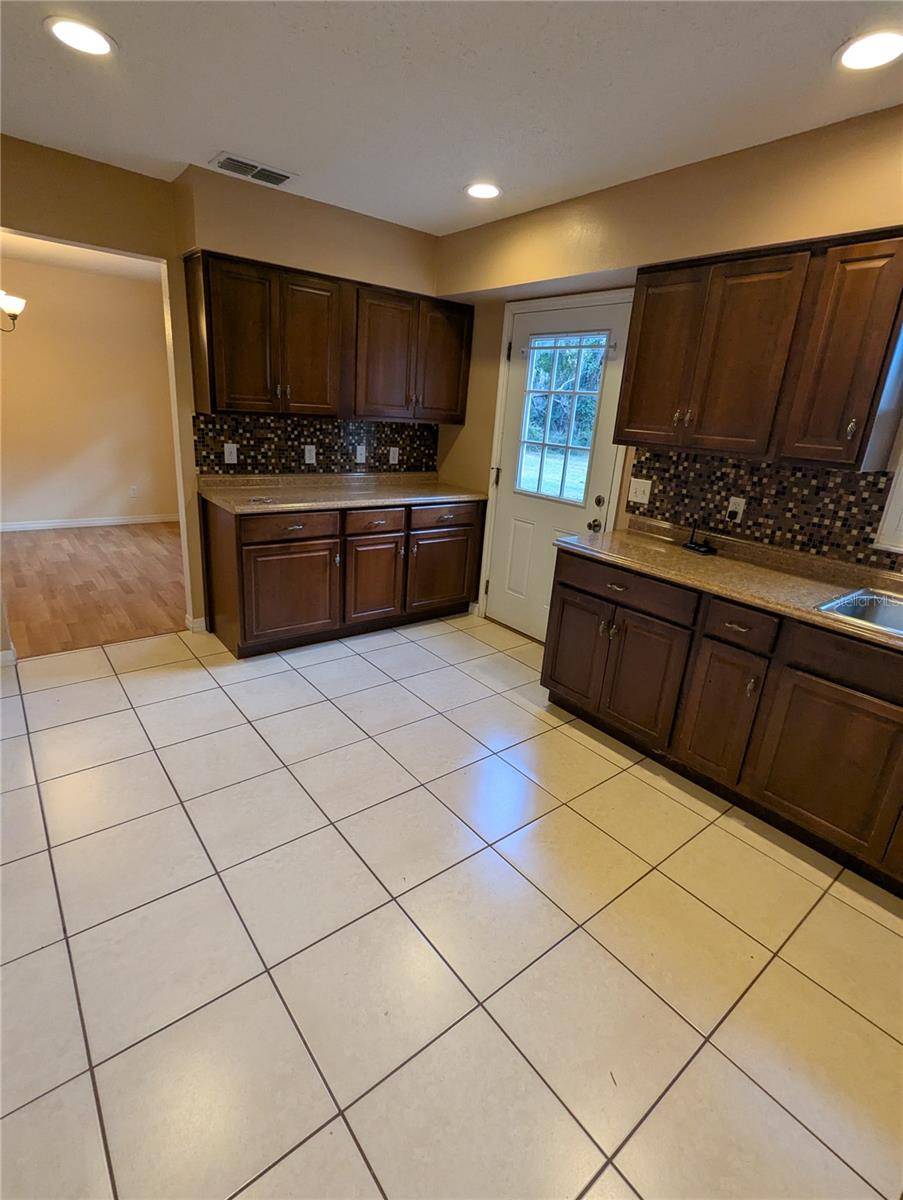 Kitchen Area looking towards formal dining room and showing back door to back yard. So many cabinets!!