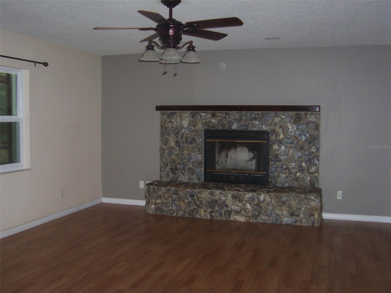 Living Room features beautiful stone wood burning fireplace.
